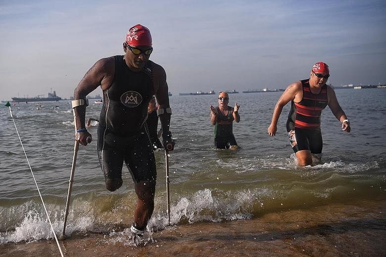 Amputee Abdul Alim, 44, taking part in the 2km men's open/ veteran swim category at the Tri-Factor Series held yesterday morning at East Coast Park. Erasmus Ang, 17, won the 2km open water swim race in 30min 32sec, while Amos Tan, 46, won the 2km vet