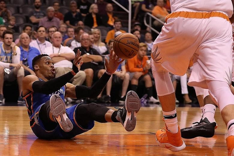 Russell Westbrook of Oklahoma City grabbing a rebound even as he takes a tumble. He is much more likely to be MVP than win the NBA title with the Thunder.