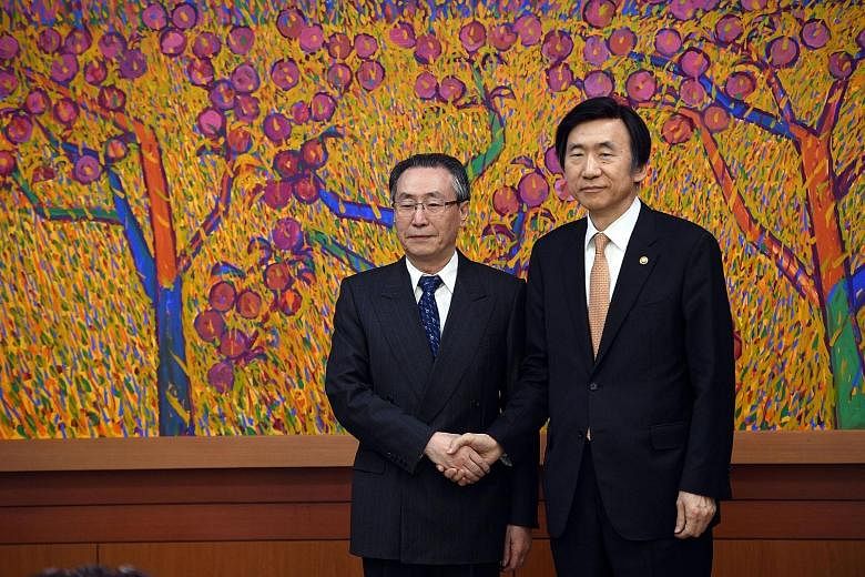 South Korean Foreign Minister Yun Byung Se (at right) with China's Mr Wu Dawei during their meeting in Seoul yesterday. Mr Wu's trip was the first visit to South Korea by a senior Chinese official after the planned deployment of the US Thaad missile 