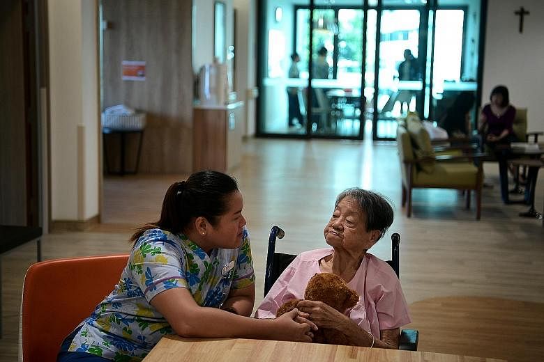Nurse Joanna Rose Evardone interacting with Madam Liow Ah Tay last week. Madam Liow is among the pioneer batch of patients at Assisi's dementia ward.