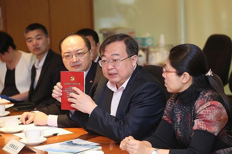 Mr Liu Jianchao with a book on law and regulations issued to Communist Party members. He was speaking to journalists from Singapore Press Holdings yesterday.