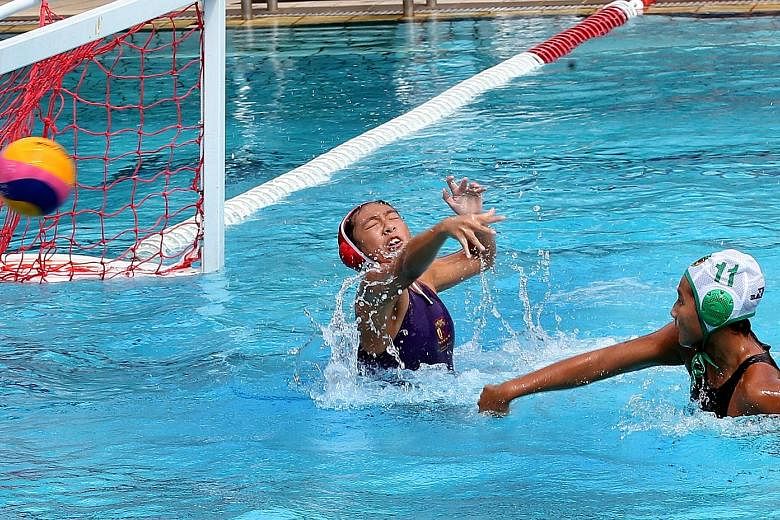 ACS(I) goalkeeper Yin Yihui trying to parry a shot during yesterday's Schools National A Division girls' water polo final. Despite her strong performance, RI still won 15-1.