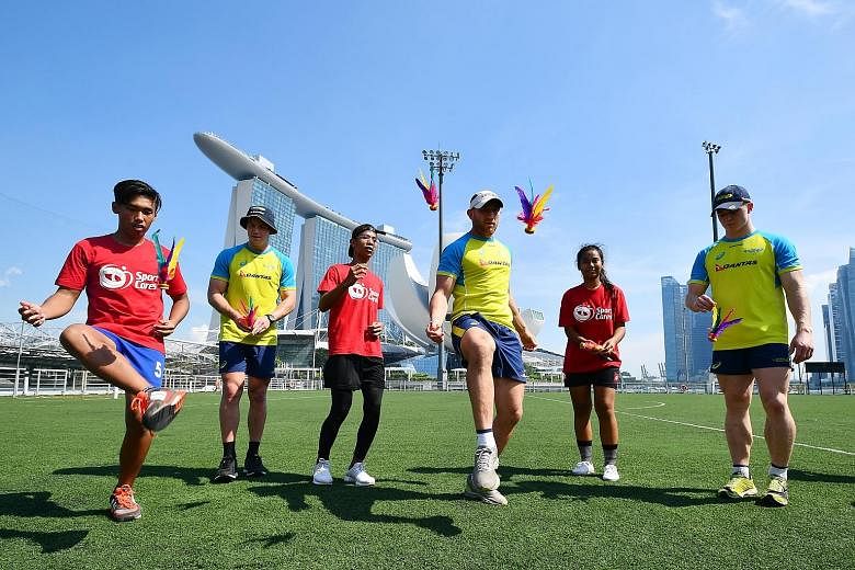 Australia's Rugby Sevens players (from left, in yellow jerseys) Nick Malouf, James Stannard and Henry Hutchison learnt to play chapteh from SportCares participants (in red) Zulkilfli Najib, Dinie Irfan Abdul Raup and Noorisha Elfira Helmy. They were 