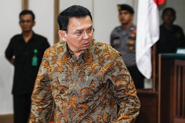 Right: Protesters marching at a rally against Jakarta Governor Basuki Tjahaja Purnama in the capital yesterday. Below: Basuki at the North Jakarta District Court yesterday. He is on trial for blasphemy and faces up to four years' jail if found guilty