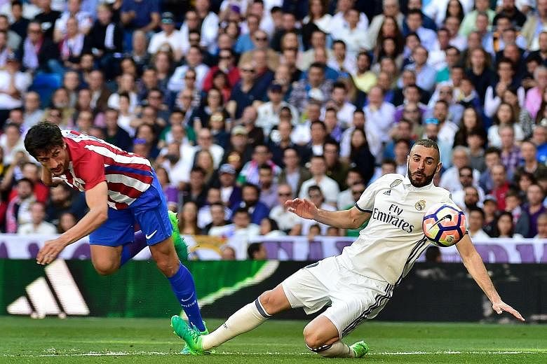 Real Madrid forward Karim Benzema goes one-on-one against Atletico Madrid defender Stefan Savic. The Frenchman, along with Gareth Bale and Cristiano Ronaldo, must find improved form for the Champions League encounter against Bayern Munich tonight.