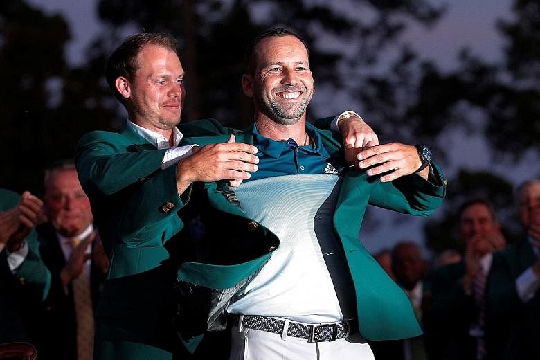 Last year's Masters champion Danny Willett helping Sergio Garcia put on the green jacket after the Spaniard's play-off win at Augusta.