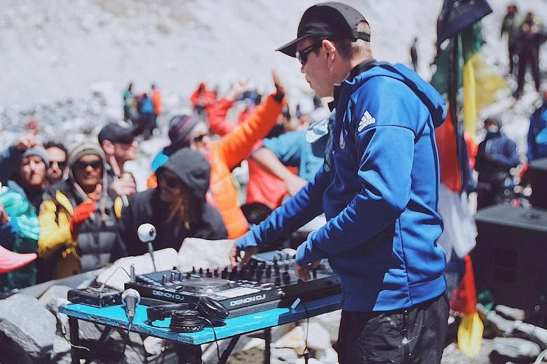 DJ Paul Oakenfold trekked for 10 days (above) to reach Everest base camp and performed on a makeshift stone stage (top) to draw attention to global warming and raise money for charities.