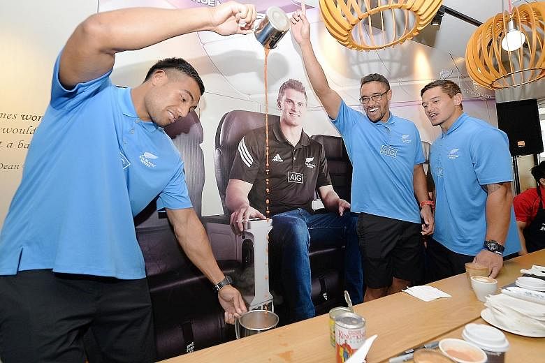 Sione Molia of the New Zealand Sevens side shows his hand-to-eye coordination while learning how to prepare teh tarik as his team-mates cheered him on at Baker & Cook yesterday.