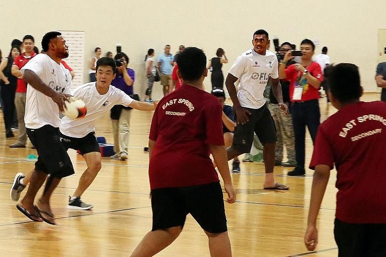 Fiji players in a rugby sevens clinic with 50 students from SportCares' school partners at the OCBC Arena yesterday. After losing three finals this year, the team are rejuvenated by their victory in Hong Kong.