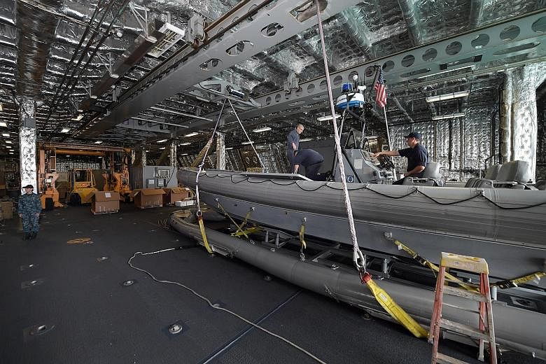 A rigid-hulled inflatable boat in the large mission bay of the USS Coronado, which can be easily configured for different operations. The Harpoon missile launchers (above) on the USS Coronado (right) at Changi Naval Base on Wednesday. Last July, the 