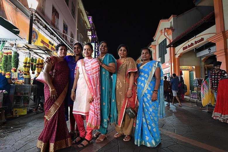 Madam Mohan Sumathy (fourth from left) with her family members in Campbell Lane last night. The family ended their New Year's Day watching a display of fireworks. Madam Sumathy's family had risen at 6am to decorate the entrance of their home, pray an