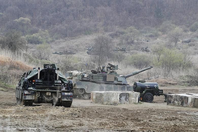 US Army soldiers with M1A2 tanks participating in a defence exercise conducted to simulate a response to an attack from North Korea, at a drill field in Gyeonggi province, South Korea, yesterday.