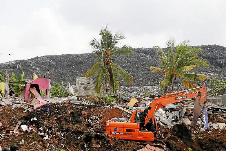 Soldiers use an excavator to dig through tonnes of rubbish to look for victims after a 91m-high garbage dump crashed on homes in Kolonnawa, Colombo, on Friday, leaving 19 people dead. The authorities said the death toll would have been much higher ha