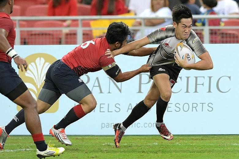 Mattias Chia of Singapore brushing aside his Malaysian opponent to score a try in a 19-7 win to clinch the host nation's first SEA sevens trophy. The triumph will put them in good stead ahead of August's SEA Games in Kuala Lumpur, where they will be 