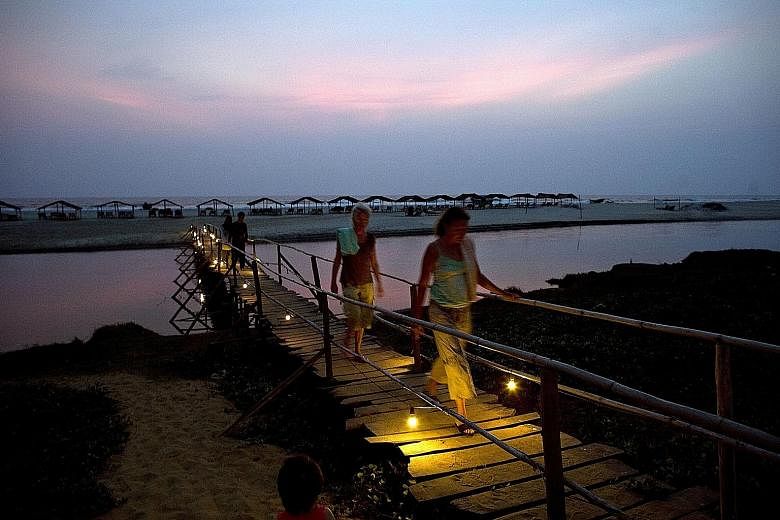 Western tourists at Mandrem Beach in Goa, which lures millions of tourists yearly with its nightlife and sandy beaches.