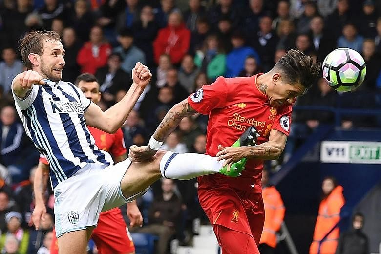 Liverpool midfielder Roberto Firmino beating West Brom defender Craig Dawson to head home a free kick for the only goal at The Hawthorns. The third-placed Reds have 66 points, two more than City.