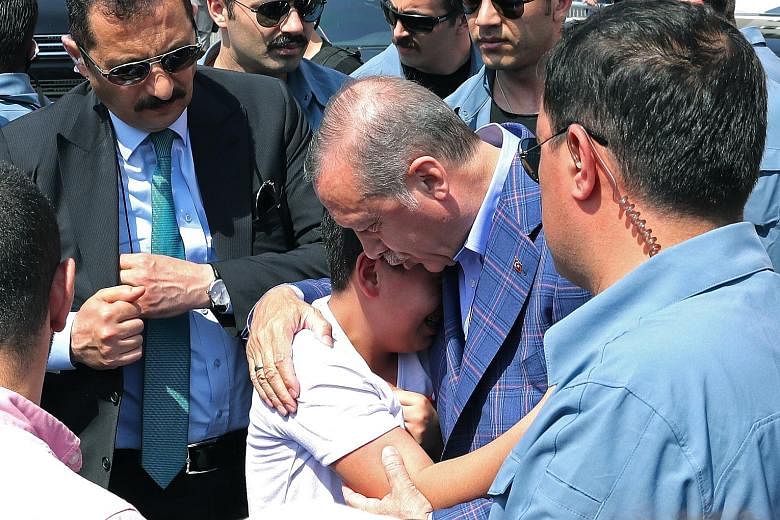 Turkish President Recep Tayyip Erdogan comforting a young supporter after voting at a polling station yesterday. Some 55 million people were eligible to vote at 167,140 polling stations.