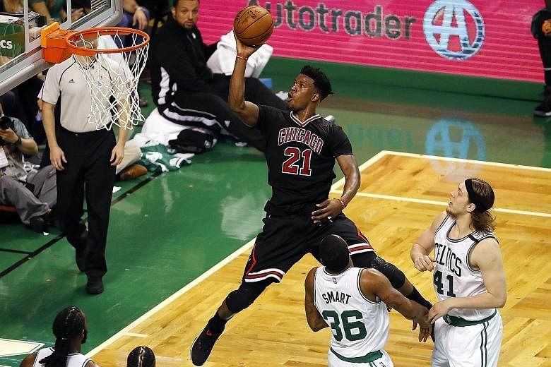 Chicago forward Jimmy Butler going to the basket past Boston guard Marcus Smart and centre Kelly Olynyk in the Bulls 106-102 win at Boston's TD Garden.