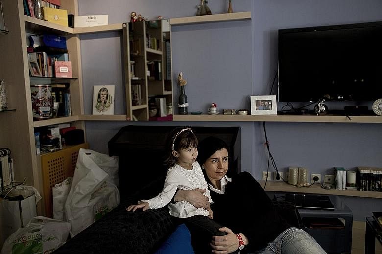 Ms Maria Karaklioumi in her Athens apartment with her four-year-old niece Georgia. The pollster has decided against having children for fear that she will not be able to offer them a stable future