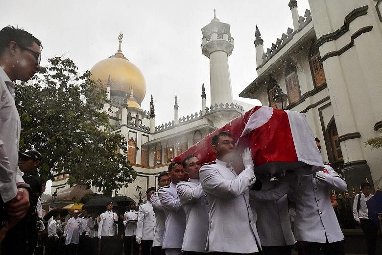 Pallbearers carrying Mr Othman Wok's coffin outside Sultan Mosque yesterday. A Singapore flag was draped over the coffin, with the crescent and stars lying over the head and close to the heart of one of the nation's founding fathers.