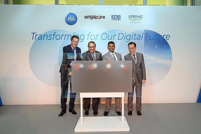 (From left) Mr Nicolas Defauw, Mr S. Iswaran, Mr Magesvaran Suranjan and Economic Development Board chairman Beh Swan Gin activating a simulated panel yesterday to symbolically launch Procter & Gamble's E-Centre in Singapore. P&G said the project rea