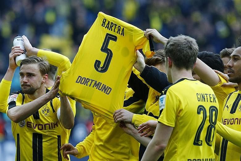 Borussia Dortmund players thanking their supporters after their 3-1 German Bundesliga home win over Eintracht Frankfurt last weekend. The shirt they are holding aloft belongs to Marc Bartra, the team's Spanish defender who suffered a fractured arm in