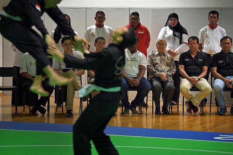 Left: National netball players during a training exercise at OCBC Arena yesterday. Below: President Tony Tan Keng Yam watching a demonstration by Singapore's pencak silat exponents yesterday.