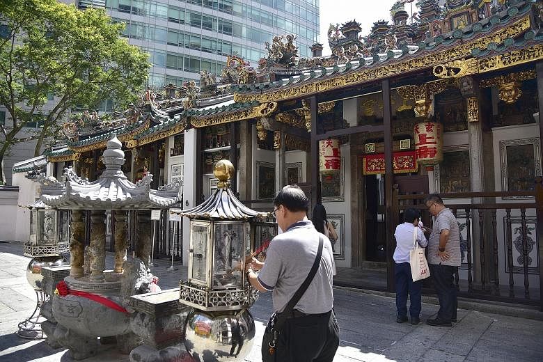 Left: Mr Ang Wenjie and Ms Chong Gaik See offering prayers to Yue Lao, the Chinese god of marriage, last November, as part of their marriage solemnisation ceremony. Right: The altar to the Jade Emperor in the temple, which also houses other famous de