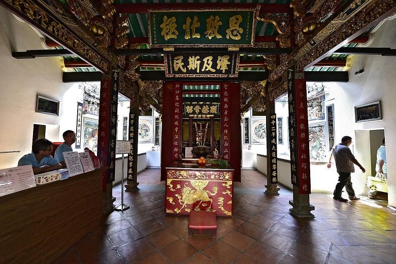 Left: Mr Ang Wenjie and Ms Chong Gaik See offering prayers to Yue Lao, the Chinese god of marriage, last November, as part of their marriage solemnisation ceremony. Right: The altar to the Jade Emperor in the temple, which also houses other famous de