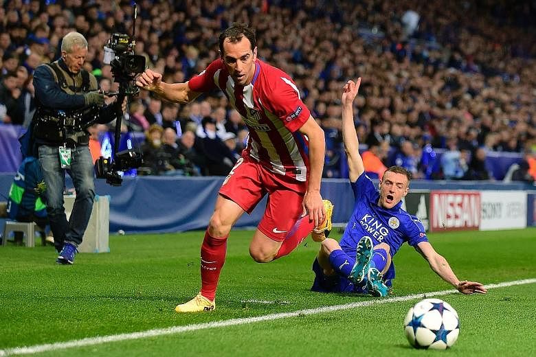 Leicester striker Jamie Vardy (right) reacts after challenging Atletico defender Diego Godin for the ball in their Champions League quarter-final second leg. Vardy equalised from close range in the second half.