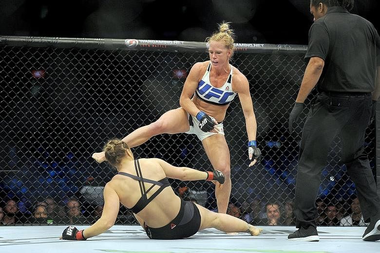 Holly Holm (top) strikes defending champion Ronda Rousey in winning their women's bantamweight bout in Melbourne in November 2015. Her three subsequent losses have created the determination to "constantly be improving" as she prepares to face Bethe C