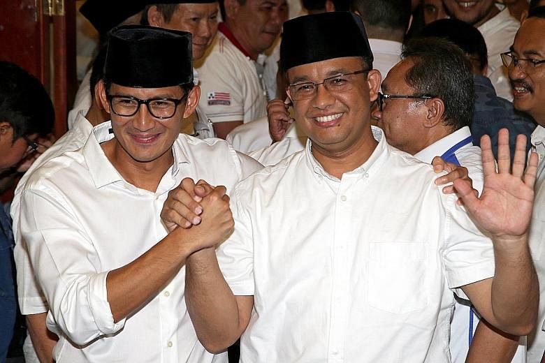 Mr Anies Baswedan (right) and his running mate Sandiaga Uno celebrating as quick counts released after the Jakarta election yesterday indicated that they won almost 60 per cent of the vote. Mr Anies pledged: "Our focus is social justice, ending inequ