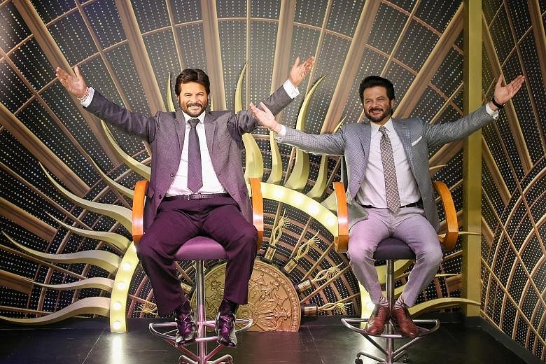 Bollywood star Anil Kapoor with a wax figure (left) of his character in Slumdog Millionaire.