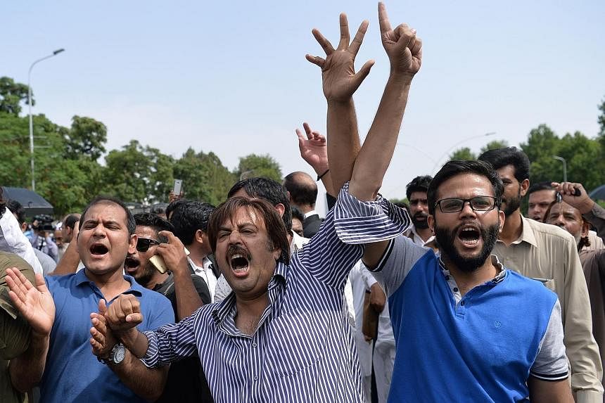 Supporters of opposition leader Imran Khan calling for the resignation of Pakistani Prime Minister Nawaz Sharif (above) after the court verdict in Islamabad yesterday. The investigation into Mr Sharif concerns the offshore wealth of his family.