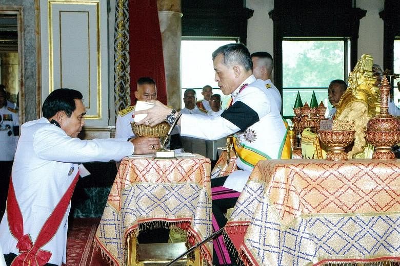 Thai King Maha Vajiralongkorn returning the new Constitution to Prime Minister Prayut Chan-o-Cha after signing it at the Ananta Samakhom Throne Hall in Bangkok.