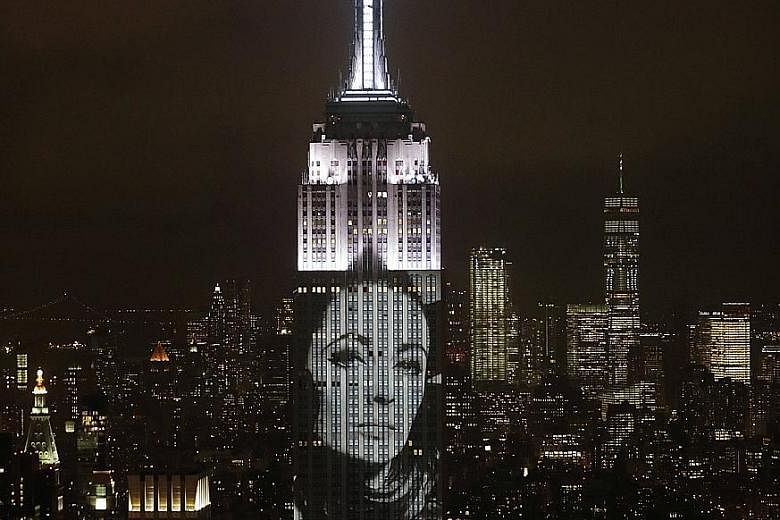 Elizabeth Taylor literally lit up another icon - the Empire State Building in New York - when the skyscraper was used on Wednesday night to celebrate the 150th anniversary of Harper's Bazaar magazine. The image of the actress, who died at age 79 in 2