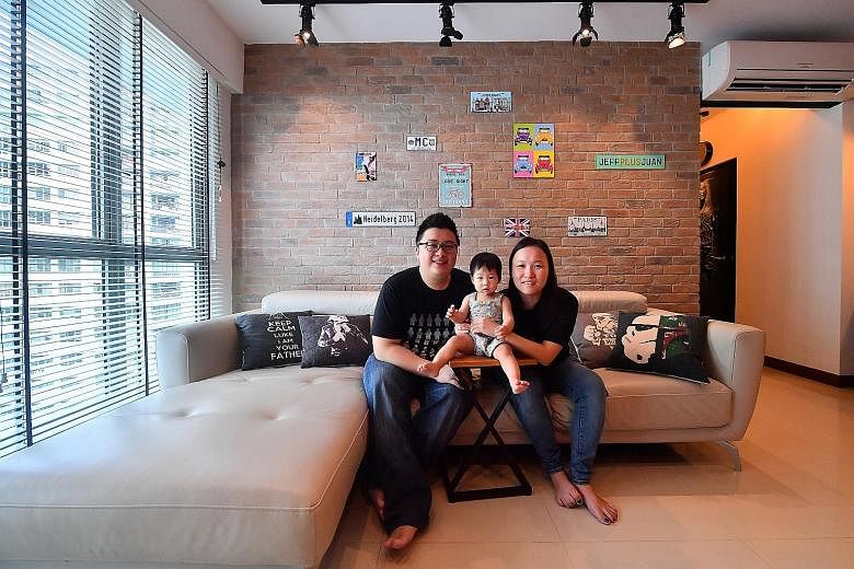 The living room of Mr Jefferson Lee and Ms Sheryl Tian (far left, with their daughter Aletheia) has red shipping container-inspired storage which displays their knick-knacks and toys.