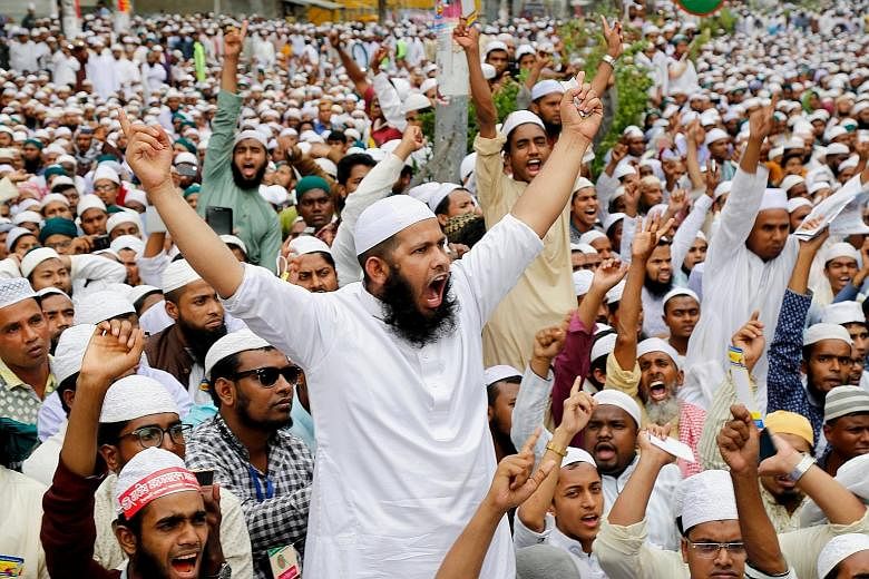 Supporters of hardline Islamist group Islami Andolan Bangladesh protesting against the "lady justice" statue (right) and asking for it to be replaced with a Quran, despite the country's secular Constitution.
