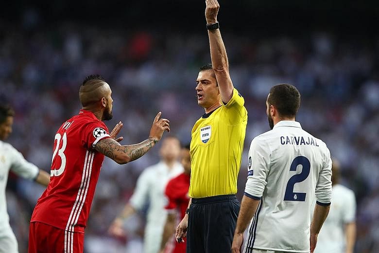 Referee Viktor Kassai shows Bayern Munich's Arturo Vidal a yellow card for a foul on Isco during the Champions League quarter-final second leg. The midfielder was dismissed for a second yellow after a challenge on Real Madrid's Marco Asensio despite 