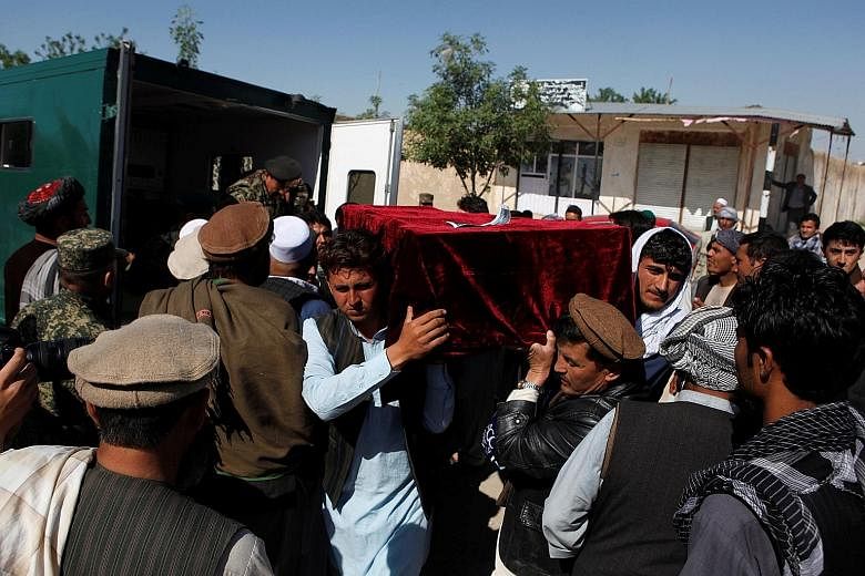 Relatives carrying a victim's coffin yesterday, a day after a Taleban attack on an army base in Mazar-i-Sharif in northern Afghanistan. The attack began at around 1pm in a crowded area where soldiers were leaving Friday prayers or eating lunch.