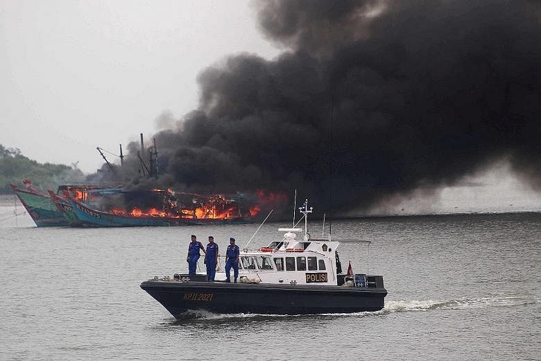 Foreign boats confiscated from poachers being destroyed near Medan on April 1. That day, 81 vessels were blown up and sunk to signal that the government is continuing its fight against illegal fishing in its waters.
