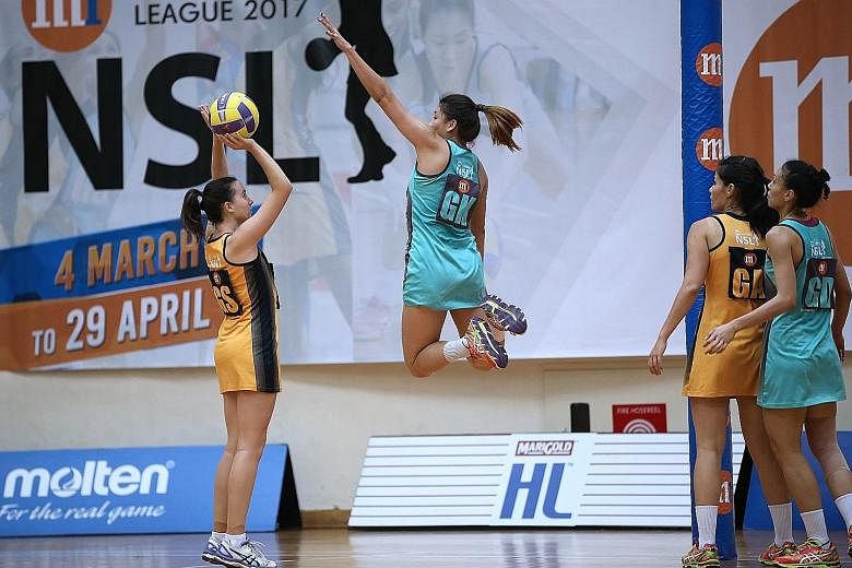 Tiger Sharks' goalkeeper Shina Teo attempting to block Fier Orcas' goal-shooter Leah Brokmann in yesterday's Netball Super League preliminary final at the Toa Payoh Sports Hall. The Tiger Sharks beat the Fier Orcas 59-47 to reach Saturday's grand fin