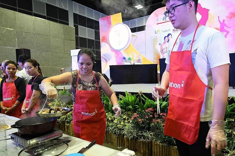 Ms Michelle Delos Santos Macaraeg (at the wok), 36, and her employer's son, Mr Darren Lee (right), 26, won the cooking competition.