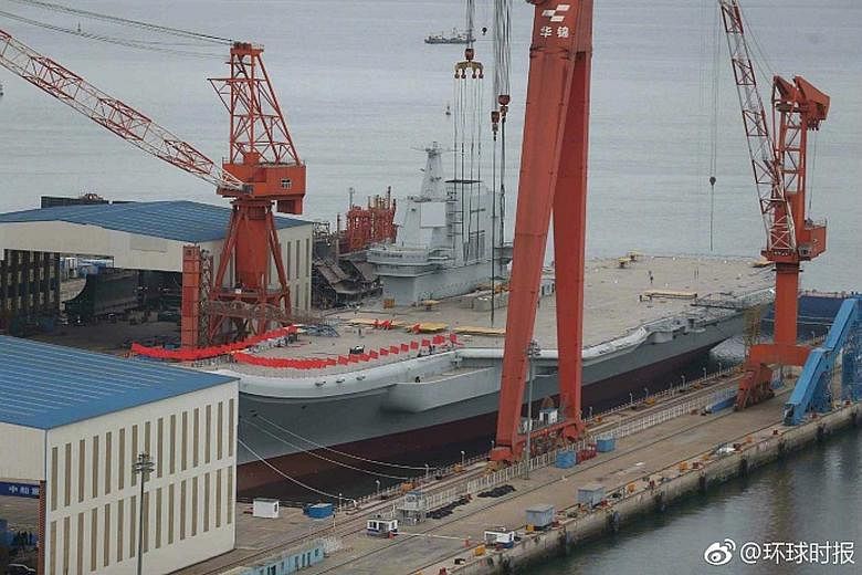 Red flags line the flight deck of China's first locally-built aircraft carrier, which is expected to be launched soon.
