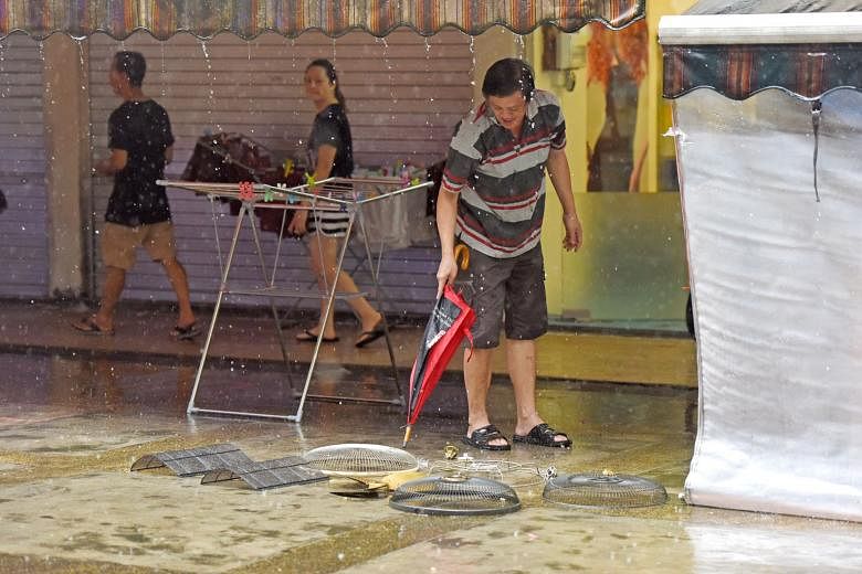 A man washing his wares with rainwater during a heavy downpour at Block 37, Circuit Road, at noon yesterday. Keep the umbrella handy as the prevailing inter-monsoon conditions over Singapore are expected to persist and extend into next month. Moderate to 