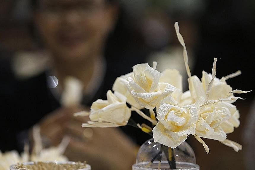 Volunteers making flowers at the Thai-Japan Youth Centre in Bangkok yesterday. The blooms will be used in the royal crematorium for the late Thai King Bhumibol Adulyadej's cremation ceremony. Three million flowers are being made, and will be given to