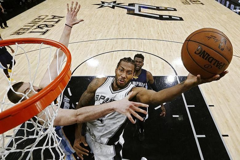 San Antonio Spurs star Kawhi Leonard is challenged by Memphis Grizzlies centre Marc Gasol as he drives for a lay-up during their Game Five NBA first-round play-off series. Leonard scored 28 points to lead the Spurs to a 116-103 win.
