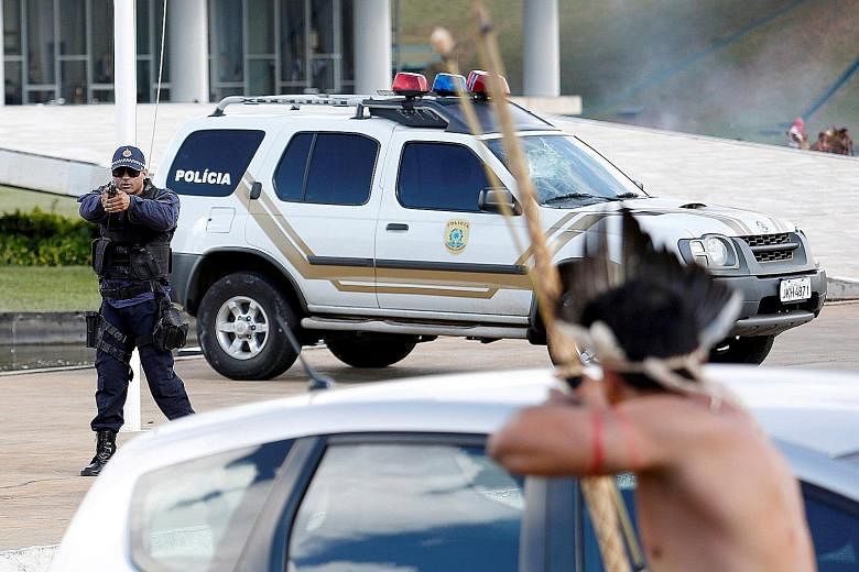 A policeman facing off against a member of an indigenous tribe in Brazil during a protest over land rights on Tuesday.