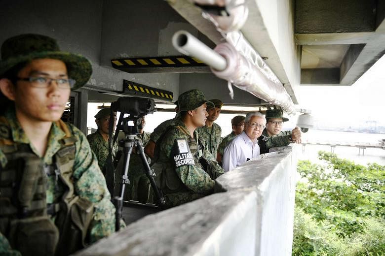 President Tony Tan Keng Yam taking a tour of the observation tower in Jurong Island yesterday. He visited operationally ready national servicemen from the 823rd Battalion of the Singapore Infantry Regiment on Jurong Island. 