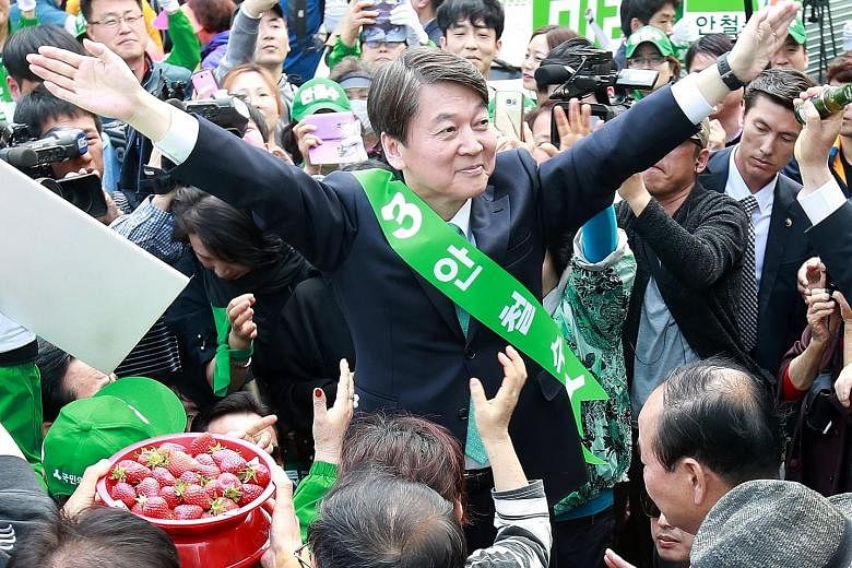 Far left: Mr Ahn Cheol Soo during a campaign stop in South Gyeongsang province last week. Left: Mr Moon Jae In (in dark jacket) with comic actor and impersonator Kim Min Kyo in Seongnam on Thursday.